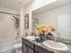 Bathroom featuring dual sinks, shower-tub combo, and elegant decor at 17012 Oval Rum Dr, Wimauma, FL 33598