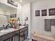Bathroom with dual sinks, granite countertops and decorative accents at 17012 Oval Rum Dr, Wimauma, FL 33598