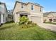 Charming two-story home featuring a well-maintained lawn, beautiful landscaping, and an attached two-car garage at 17012 Oval Rum Dr, Wimauma, FL 33598
