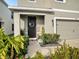 Inviting front entrance featuring a well-manicured garden and a covered porch with a stylish front door at 17012 Oval Rum Dr, Wimauma, FL 33598