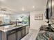Open kitchen with stainless appliances, granite countertops, and eat-in island at 17012 Oval Rum Dr, Wimauma, FL 33598