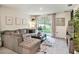 Bright living room featuring a comfortable couch, and large window with outdoor views at 17012 Oval Rum Dr, Wimauma, FL 33598
