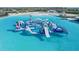 Water park featuring floating inflatable obstacles and slides set in a large lagoon with clear blue water at 17012 Oval Rum Dr, Wimauma, FL 33598