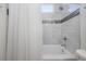 Bathtub and shower combo featuring neutral tile and shower curtain at 1813 Hillside Dr, Tampa, FL 33610