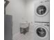 Modern laundry room featuring a stacked washer and dryer and utility sink at 1813 Hillside Dr, Tampa, FL 33610