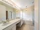 Bright bathroom with dual sinks, large mirror, soaking tub, and separate glass enclosed shower at 1932 Sean Wood Cir, Brandon, FL 33510
