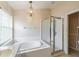 Bright bathroom featuring a soaking tub, glass enclosed shower, and decorative chandelier at 1932 Sean Wood Cir, Brandon, FL 33510