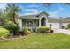 Charming single-story home with meticulously landscaped front yard, mature palms, and an attached two-car garage at 1932 Sean Wood Cir, Brandon, FL 33510