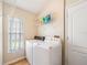 Functional laundry room with a washer, dryer, shelving, and natural light from a window at 1932 Sean Wood Cir, Brandon, FL 33510