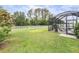 Spacious backyard with a well-manicured lawn, privacy fence, and screened in patio at 19608 Lonesome Pine Dr, Land O Lakes, FL 34638