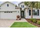 Charming stucco home featuring a well-manicured lawn, paver driveway, and colorful flower bed near the garage at 19608 Lonesome Pine Dr, Land O Lakes, FL 34638