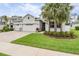 Charming home featuring a three-car garage, well-manicured lawn, and tropical palm trees adding curb appeal at 19608 Lonesome Pine Dr, Land O Lakes, FL 34638