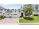 Charming home featuring a three-car garage, well-manicured lawn, and tropical palm trees adding curb appeal at 19608 Lonesome Pine Dr, Land O Lakes, FL 34638