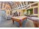 Elegant game room featuring a pool table, lounge areas, and a high ceiling, perfect for social activities and entertainment at 19608 Lonesome Pine Dr, Land O Lakes, FL 34638