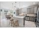 Contemporary kitchen showcasing stainless appliances, island seating, and an adjacent dining area filled with light at 19608 Lonesome Pine Dr, Land O Lakes, FL 34638