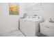 Well-lit laundry room features a white washer and dryer, utility sink, and additional storage shelf at 19608 Lonesome Pine Dr, Land O Lakes, FL 34638