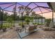 Outdoor screened patio with comfortable seating perfect for relaxing and entertaining with string lights at dusk at 19608 Lonesome Pine Dr, Land O Lakes, FL 34638