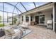 Spacious screened-in patio with comfortable seating, ceiling fan, and outdoor grill, ideal for entertaining at 19608 Lonesome Pine Dr, Land O Lakes, FL 34638