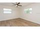 Well-lit bedroom with two windows, a ceiling fan, and wood-look flooring at 2146 Waterside Dr, Clearwater, FL 33764