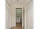 Hallway leading to bathroom showcasing white doors, new flooring and fresh paint at 2146 Waterside Dr, Clearwater, FL 33764