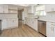 Bright kitchen features all-white cabinets, stainless steel appliances, wood floors and quartz countertops at 2146 Waterside Dr, Clearwater, FL 33764