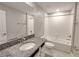 Bright bathroom featuring a granite vanity, soaking tub with shower, and white cabinets at 23300 Willow Glen Way, Lutz, FL 33549