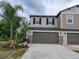Gorgeous townhome with dark shutters, stone accents, and an attached two-car garage on a cloudy day at 23300 Willow Glen Way, Lutz, FL 33549