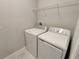A laundry room with a washer, dryer, and white storage shelf above at 23300 Willow Glen Way, Lutz, FL 33549
