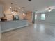 Open-concept living space with tile floors and a kitchen featuring a breakfast bar and stainless appliances at 23300 Willow Glen Way, Lutz, FL 33549