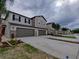 A beautiful street view of townhomes with a two-car garage and well-manicured lawns on a cloudy day at 23300 Willow Glen Way, Lutz, FL 33549