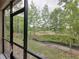 View from the screened in back porch of a wooded lot with trees and grass at 23300 Willow Glen Way, Lutz, FL 33549