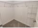 An empty carpeted walk-in closet space with metal shelving around the top at 23300 Willow Glen Way, Lutz, FL 33549