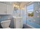 Tiled bathroom featuring a blue tub and shower combination, vanity, mirror, and toilet at 241 72Nd N St, St Petersburg, FL 33710