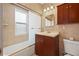Cozy bathroom with a combination tub and shower, dark wood vanity, and neutral tile at 241 72Nd N St, St Petersburg, FL 33710