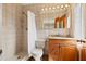 Tiled bathroom with a shower, vanity with a granite countertop, mirror and toilet at 241 72Nd N St, St Petersburg, FL 33710