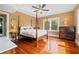 Cozy bedroom featuring hardwood floors, a four-poster bed, and natural light at 241 72Nd N St, St Petersburg, FL 33710