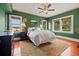 Spacious bedroom with green walls, hardwood floors, large windows and a decorative rug at 241 72Nd N St, St Petersburg, FL 33710