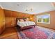 Bedroom with wood-paneled walls, hard wood floors, a rug and a comfortable bed at 241 72Nd N St, St Petersburg, FL 33710