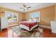 Well-lit bedroom featuring a bed with a leaf-patterned rug, wood floors and three windows at 241 72Nd N St, St Petersburg, FL 33710