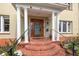 Charming front entrance with brick steps, white columns, and a decorative glass-paneled wooden door at 241 72Nd N St, St Petersburg, FL 33710