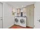 Well-lit laundry room with side-by-side washer and dryer, with custom overhead cabinet storage at 241 72Nd N St, St Petersburg, FL 33710