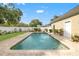 A private pool with a brick paver deck is surrounded by a white fence and lush landscaping at 241 72Nd N St, St Petersburg, FL 33710