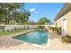 A private pool with a brick paver deck is surrounded by a white fence and lush landscaping at 241 72Nd N St, St Petersburg, FL 33710