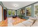 Bright sunroom with terra cotta tile, large windows, and comfortable seating area with neutral colors at 241 72Nd N St, St Petersburg, FL 33710