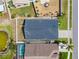 Aerial view of the home, highlighting its backyard, roof, proximity to a pond, neighbor's pool, and the street at 2641 Big Pine Dr, Holiday, FL 34691