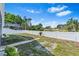 Spacious backyard with white fence and view of lake for outdoor enjoyment at 2641 Big Pine Dr, Holiday, FL 34691