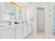 This bright bathroom offers double sinks, white cabinets and gold hardware at 2641 Big Pine Dr, Holiday, FL 34691