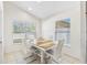 Bright dining area featuring a wood and white table with matching chairs, bathed in natural light at 2641 Big Pine Dr, Holiday, FL 34691