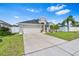 Single-story home with a manicured lawn, two-car garage, and fenced yard offering privacy at 2641 Big Pine Dr, Holiday, FL 34691