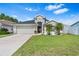 Charming single-story home with a well-manicured lawn and beautiful landscaping, including young palm trees at 2641 Big Pine Dr, Holiday, FL 34691